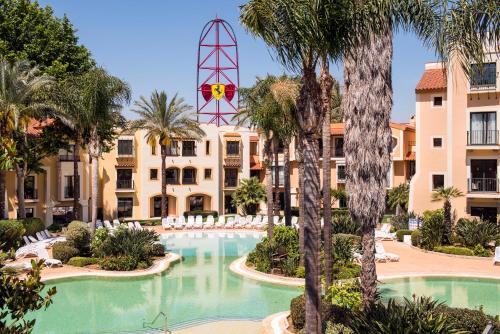 un complejo con piscina y palmeras en PortAventura Hotel Roulette - Includes unlimited access to PortAventura Park & 1 access to Ferrari Land, en Salou