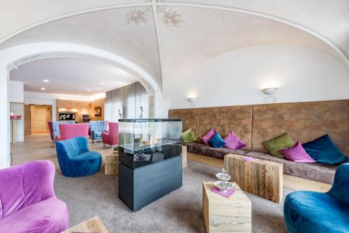 - un salon avec un grand canapé et un mobilier coloré dans l'établissement Hotel Zum Gourmet, à Seefeld in Tirol