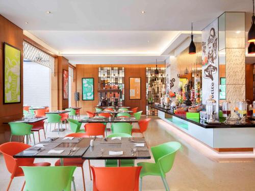 un restaurante con mesas y sillas y un bar en Ibis Styles Solo, en Solo