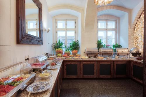 una linea a buffet con cibo in una stanza con finestre di Hotel Residence Agnes a Praga