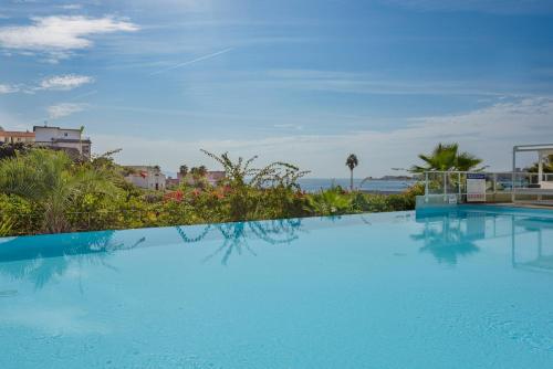 una gran piscina azul con vistas al océano en Residence de Tourisme Ajaccio Amirauté, en Ajaccio