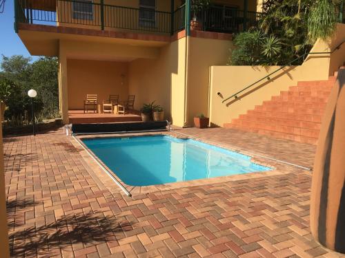 una piscina di fronte a una casa di Felsenblick Self-Catering a Windhoek