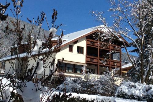 una casa en la nieve con árboles nevados en Residenze Sonnenschein Casa Bianca, en Villabassa