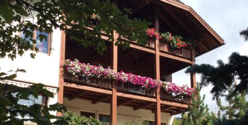 un edificio con un ramo de flores en un balcón en Residenze Sonnenschein Casa Bianca, en Villabassa