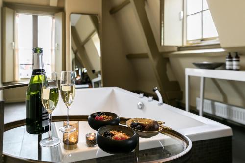 uma mesa com dois copos e uma garrafa de vinho em Brasss Hotel Suites em Haarlem