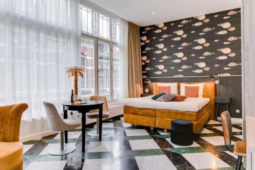 um quarto com uma cama, uma mesa e uma janela em Brasss Hotel Suites em Haarlem