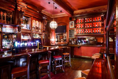 a bar with wooden bar stools in a pub at Kilkenny Hibernian Hotel in Kilkenny