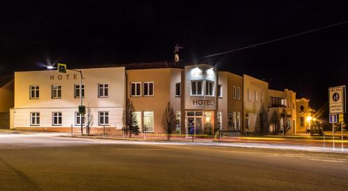 a building with a hotel on a street at night at Hotel Pangea in Telč