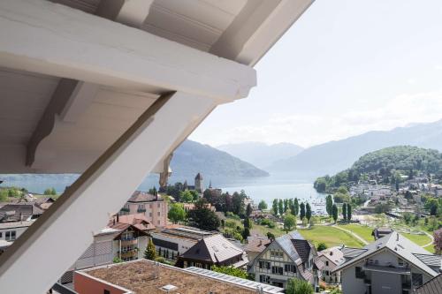 een balkon met uitzicht op een stad met een meer bij la belle vue Boutique Hotel & Café in Spiez