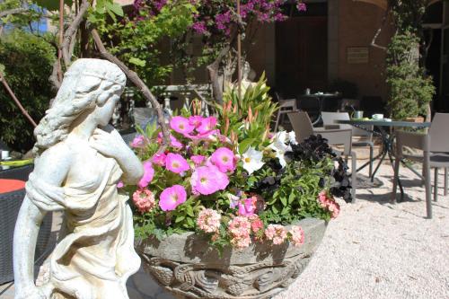 a statue of a woman next to a pot of flowers at Hôtel Les Palmiers in Saint-Tropez