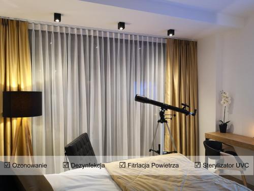 teleskop przed zasłoną z łóżkiem w obiekcie Sea View Moss VIP Apartment w Kołobrzegu