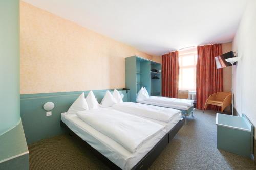 une chambre d'hôtel avec deux lits et une chaise dans l'établissement Hotel City am Bahnhof, à Berne