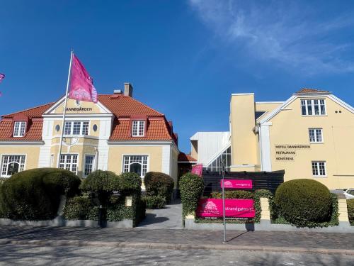 a building with a pink sign in front of it at Hotell Dannegården in Trelleborg