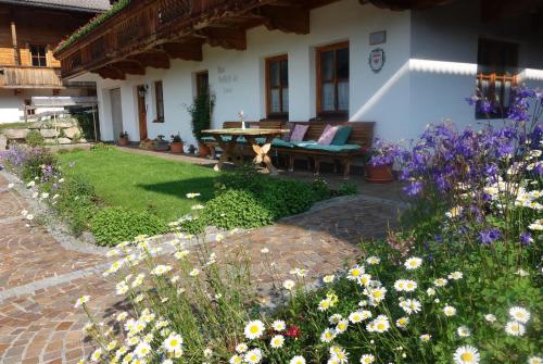 un jardín con flores frente a una casa en Haus Postfeld, en Alpbach