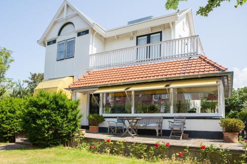 een wit huis met een tafel en stoelen bij B & B Villa Suisse in Scheveningen