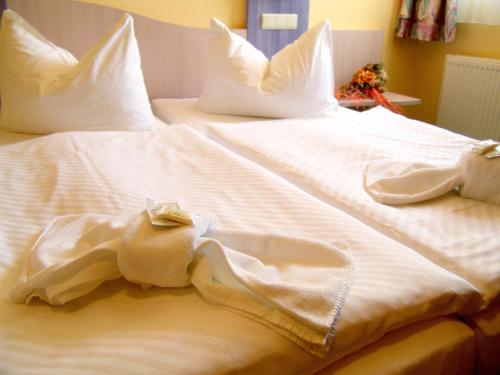 a large white bed with white sheets and pillows at Oder-Hotel in Schwedt