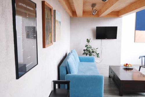 a living room with a blue couch and a table at Artists Residence Liepāja in Liepāja