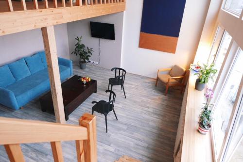 a living room with a blue couch and chairs at Artists Residence Liepāja in Liepāja