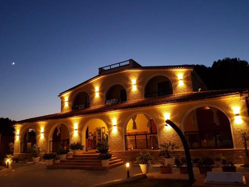 un bâtiment avec des lumières allumées la nuit dans l'établissement Villa Sunset B&B/Apartments, à Fontane Bianche