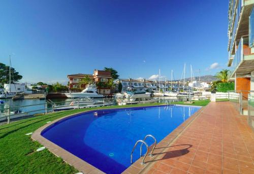 a large blue swimming pool next to a marina at Les Marines in Roses