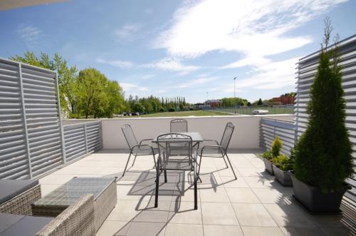 eine Terrasse mit einem Tisch und Stühlen auf dem Balkon in der Unterkunft Apartmány Viva Třeboň in Třeboň