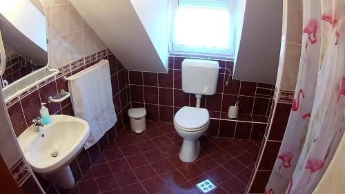 a small bathroom with a toilet and a sink at Abigél Vendégház in Harkány