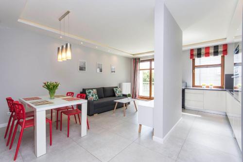 cocina y sala de estar con mesa y sillas rojas en Apartament Sopocka Przystań, en Sopot