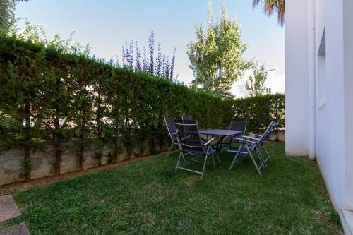 une table et des chaises assises sur l'herbe dans l'établissement Ground Floor with private garden Bellresguard, à Port de Pollença