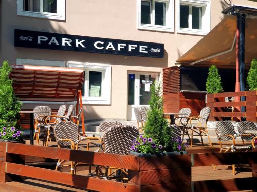 un patio con sedie e tavoli di fronte a una caffetteria di Park Rooms a Dugo Selo