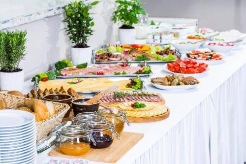 un buffet di cibi su un tavolo bianco di Hotel Nawigator Szczawnica a Szczawnica