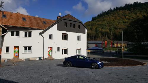 un coche azul estacionado frente a un edificio blanco en The Ring Inn, en Adenau