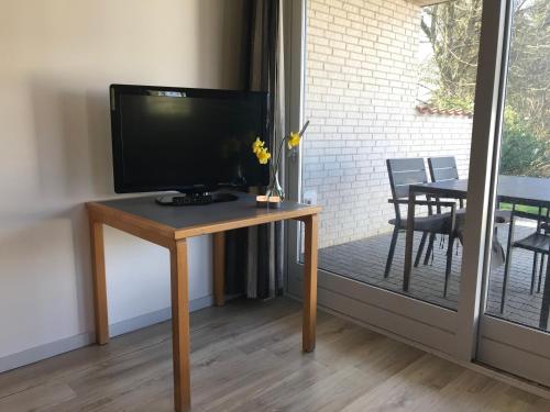 uma televisão sentada numa mesa numa sala em Medio Apartments em Fredericia