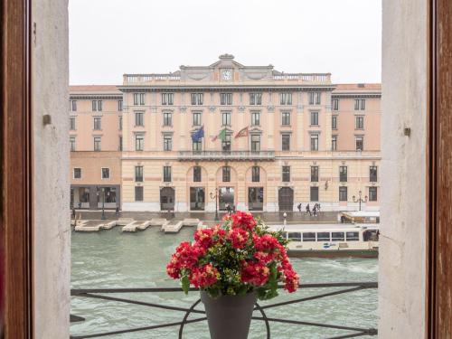 um vaso com flores em frente a um grande edifício em Grand Canal Suite by Wonderful Italy em Veneza