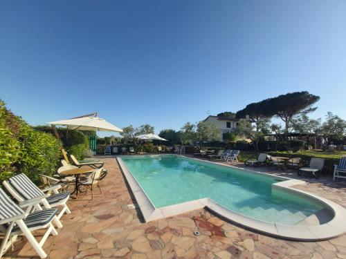 einen Pool mit Stühlen und einem Tisch in der Unterkunft Agriturismo - B&B L'Acquacotta in Castiglione della Pescaia