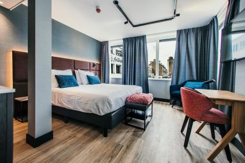 una camera d'albergo con letto, tavolo e sedie di Amsterdam Beach Hotel a Zandvoort