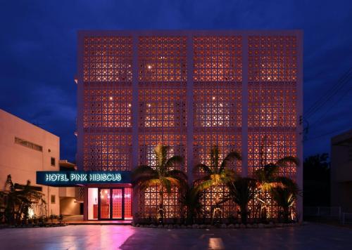 ein hohes Gebäude mit Lichtern in der Nacht in der Unterkunft HOTEL PINK HIBISCUS in Miyako-jima