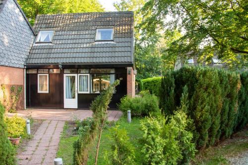 a small house with a black roof at Casita Boschberg in Biddinghuizen