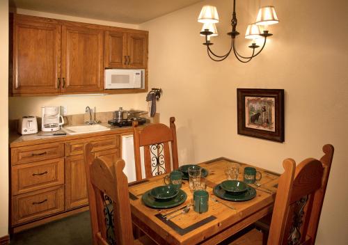 une cuisine avec une table en bois et des chaises ainsi qu'une salle à manger dans l'établissement Alpine Village Suites, à Taos Ski Valley