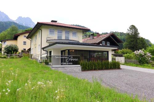 ein Haus auf einem Hügel mit einem Schild davor in der Unterkunft Appartementhaus Anna in Leogang