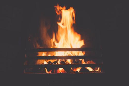 Ein Feuer brennt in einem Kamin mit Flammen in der Unterkunft Piedra Alta Hostel & Suites in La Pedrera