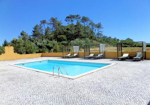 een zwembad op een patio met stoelen bij Quinta Da Torre - Óbidos Country House in Óbidos