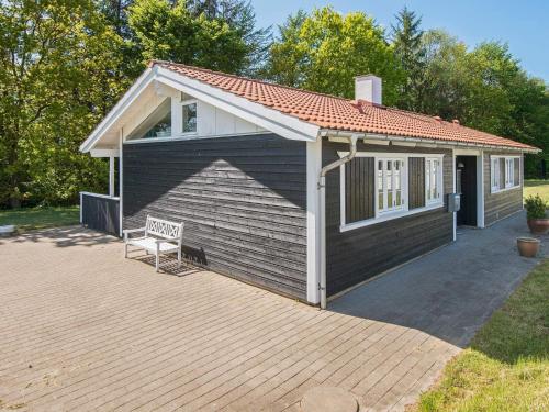 a small house with a bench on a patio at Holiday Home Sandskærvej II in Aabenraa