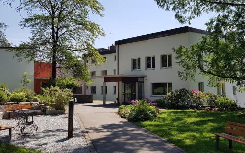 um grande edifício branco com um jardim e bancos em Le Domaine (Swiss Lodge) em Fribourg