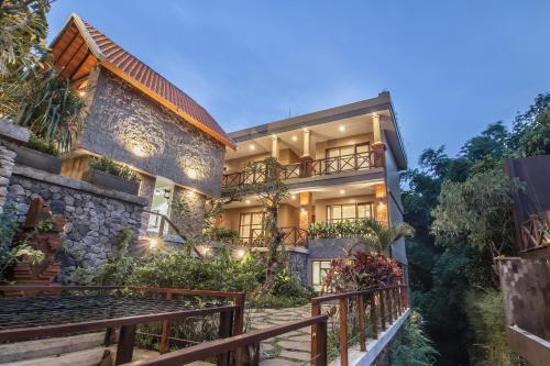 an exterior view of a house with a balcony at Merak Village by Prasi in Ubud