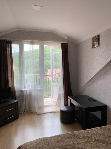 a bedroom with a bed and a window with a balcony at Guest House IBERIA in Mtskheta