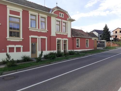 ein rotes und weißes Haus an der Straßenseite in der Unterkunft Pension U pálenice in Hrabětice