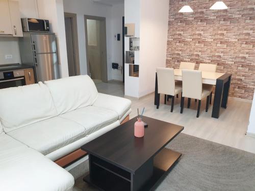 - un salon avec un canapé blanc et une table dans l'établissement Uptown Residence Apartments, à Bucarest