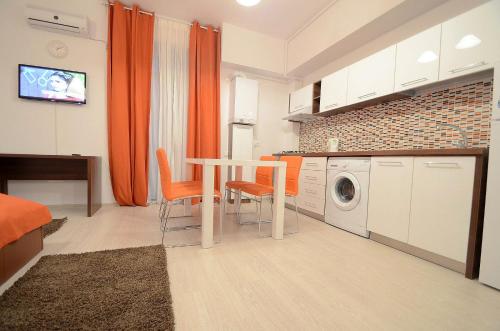 - une cuisine avec une table et un lave-linge dans l'établissement Uptown Residence Apartments, à Bucarest