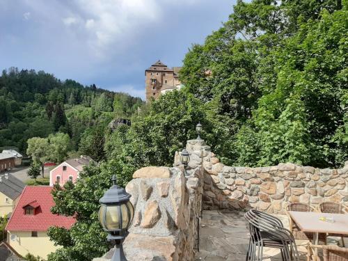 un muro di pietra con un castello sullo sfondo di Penzion - Restaurant U Zámku a Bečov nad Teplou