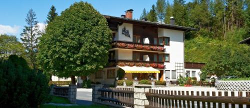 ein Gebäude mit einem Zaun davor in der Unterkunft Alpenhof Annaberg in Annaberg im Lammertal